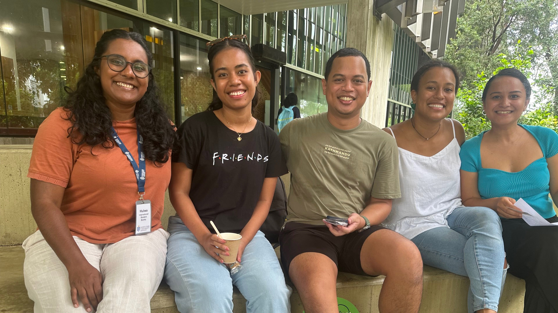 James Cook University Master of Science (Professional) student and Australia Award recipient Arnoldus Ananta sits on a bench on a JCU campus with fellow international students. 