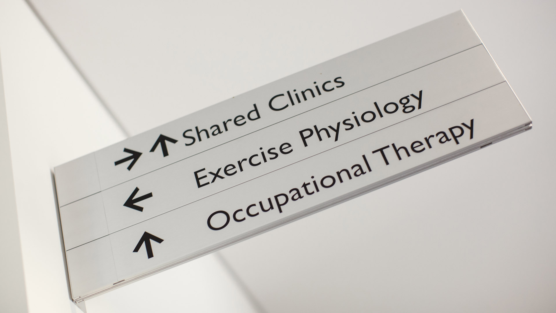 A silver sign directs patients to shared clinics, occupational therapy or exercise physiology departments. 