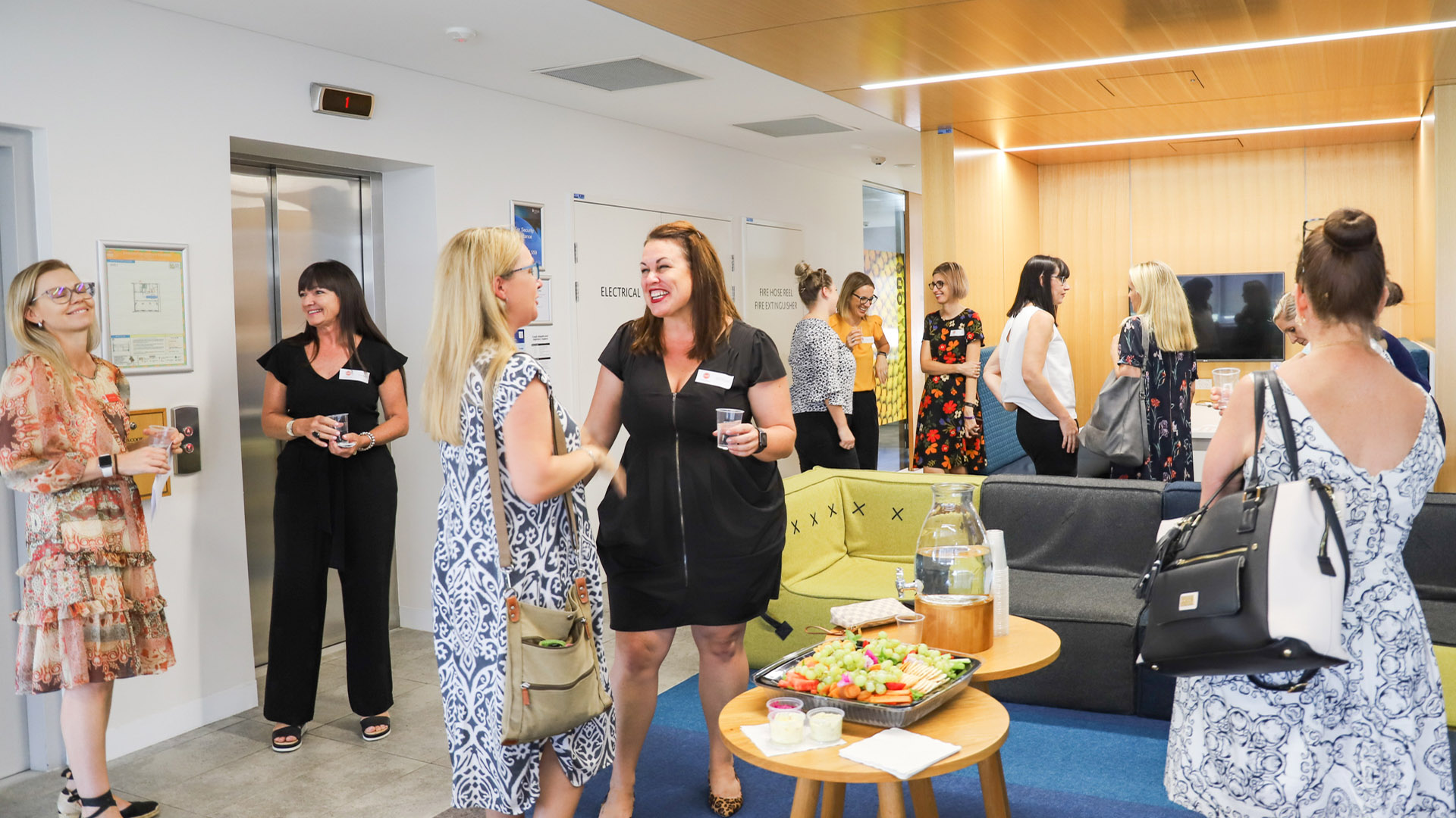 A group of businesspeople stand around networking at a James Cook University business event. 