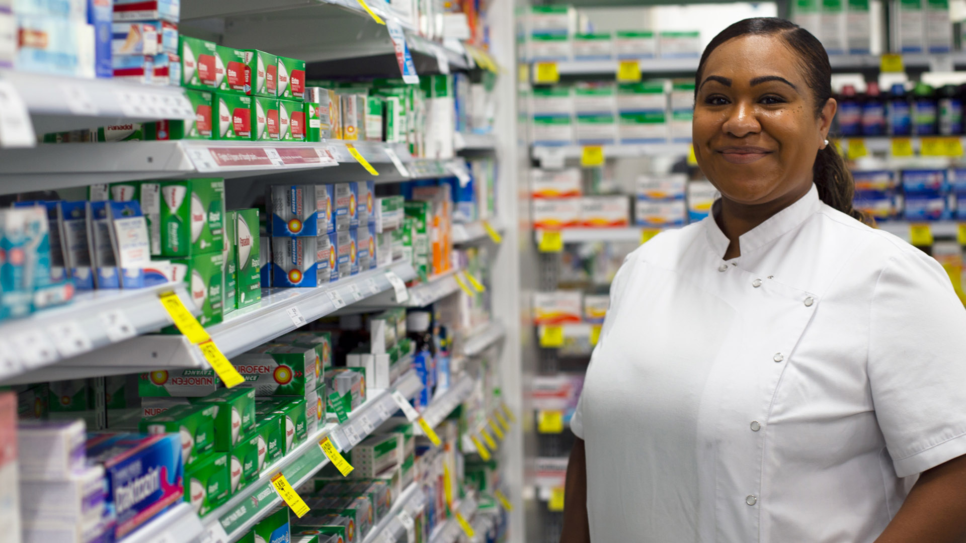 A James Cook University pharmacy student stands by a shelf of medication. 