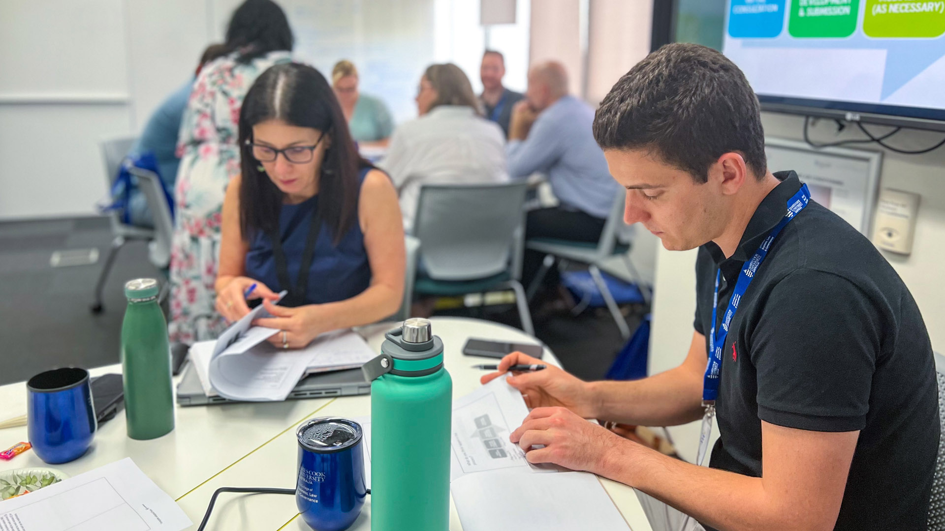 A man and a woman study course materials as part of a Project Management intensive course day on-campus at James Cook University. 