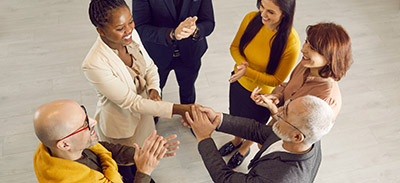 A man and a woman shake hands while conversing and networking. 